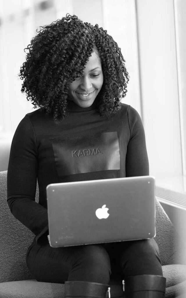 Woman with curly hair on a laptop researching SEO Services