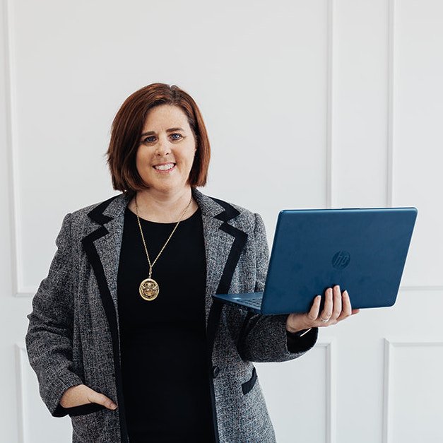 Christina Spaulding holds a computer to do your manual SEO audit
